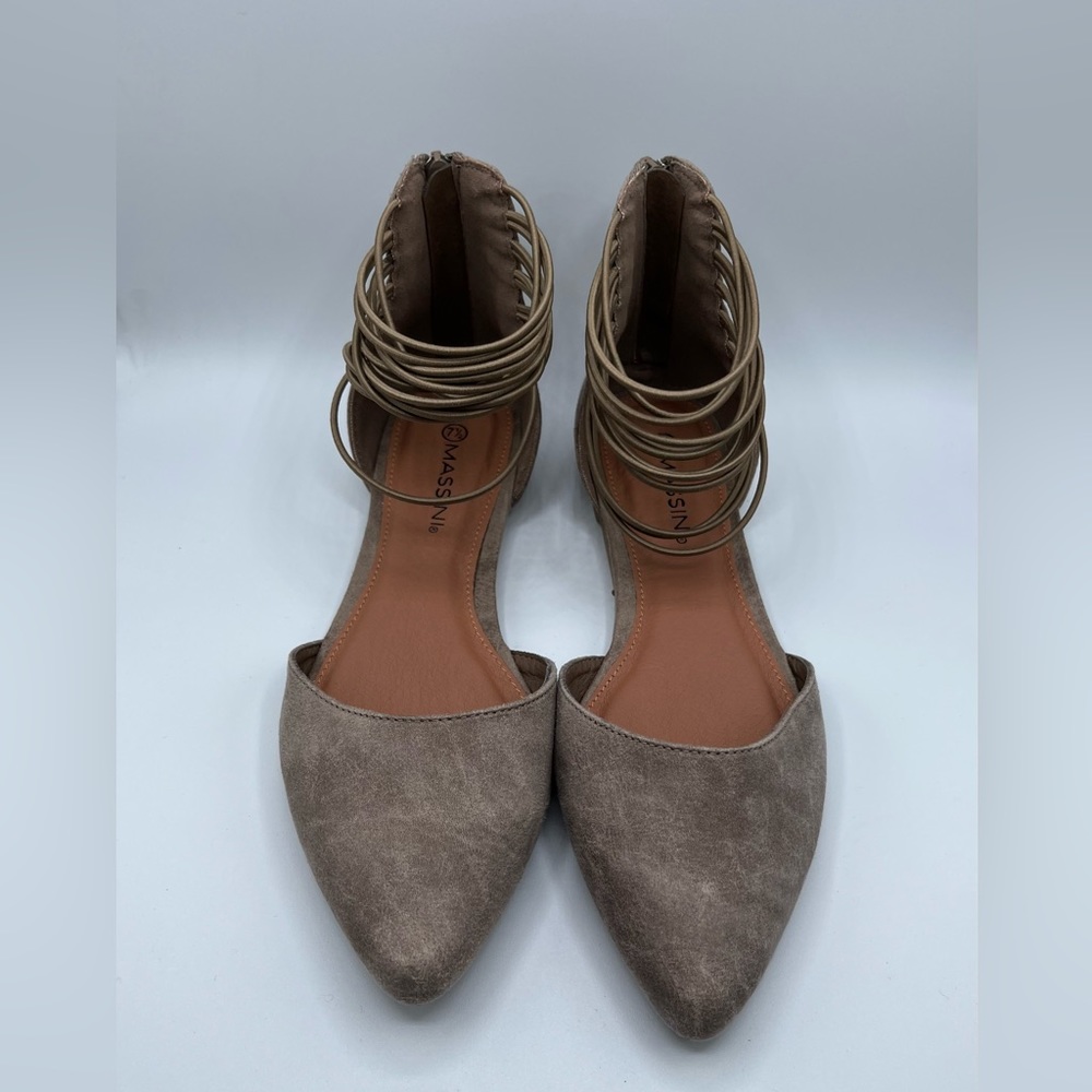Women’s pointed toe tan flats with ankle strap design.